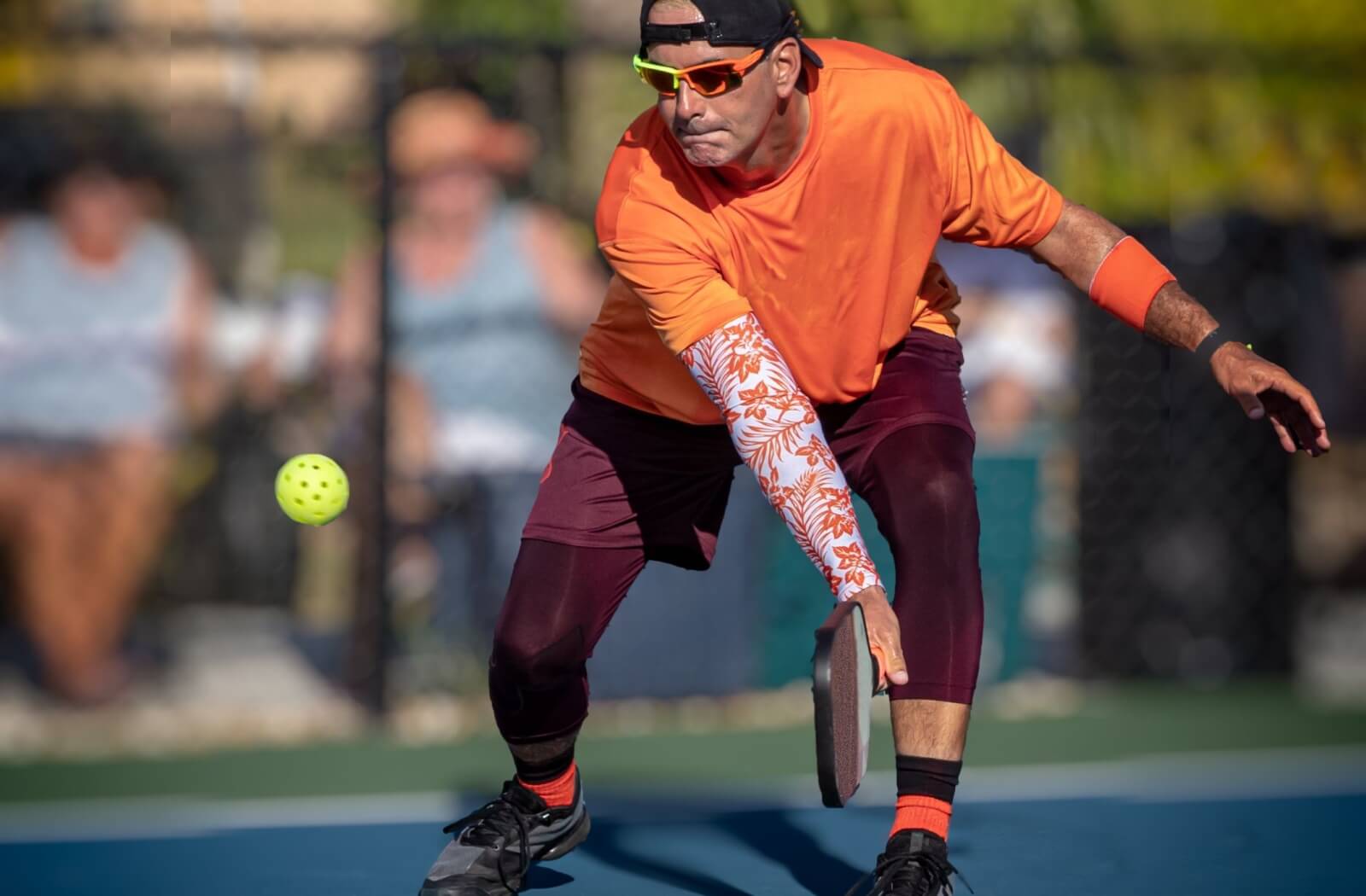 A pickleball player wears protective eyewear during their outdoor game.